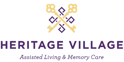 Heritage Village logo featuring two crossed keys and tagline Assisted Living & Memory Care.
