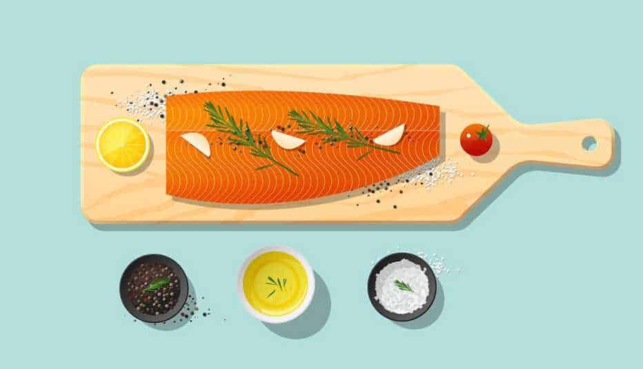 Raw salmon fillet with herbs, lemon, and spices on a wooden cutting board.