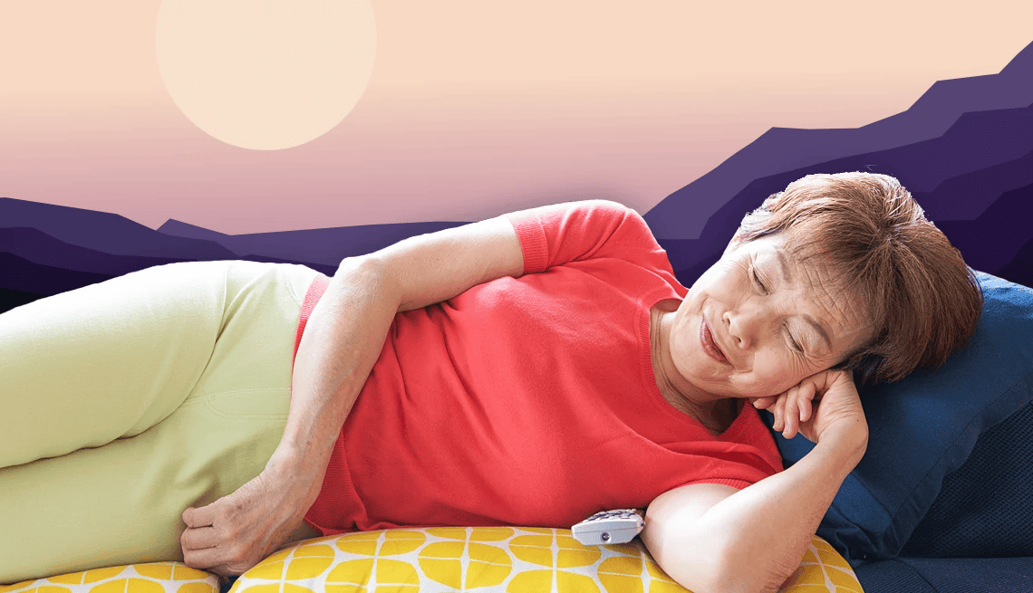 Senior woman in red shirt napping on a couch with a serene sunset background.