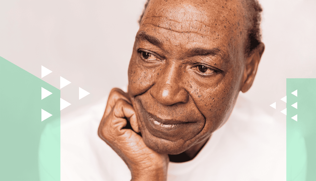 Close-up of an elderly man with thoughtful expression, resting his chin on his hand.