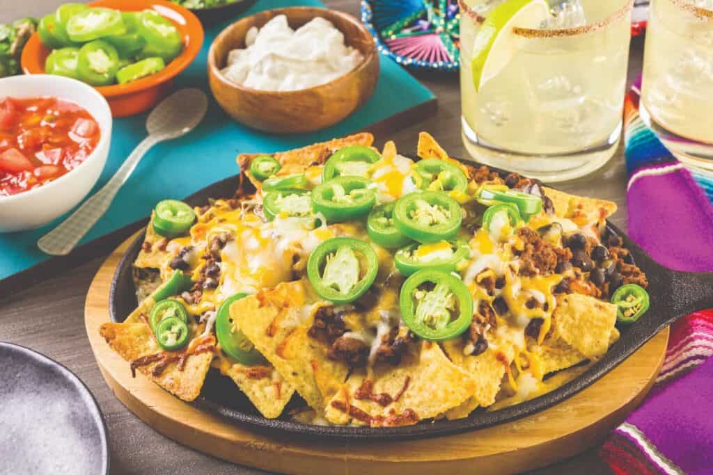 plate of loaded nachos with salsa on the side