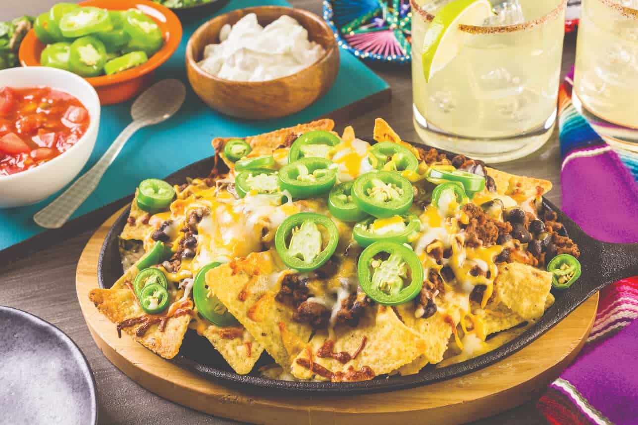 plate of loaded nachos with salsa on the side